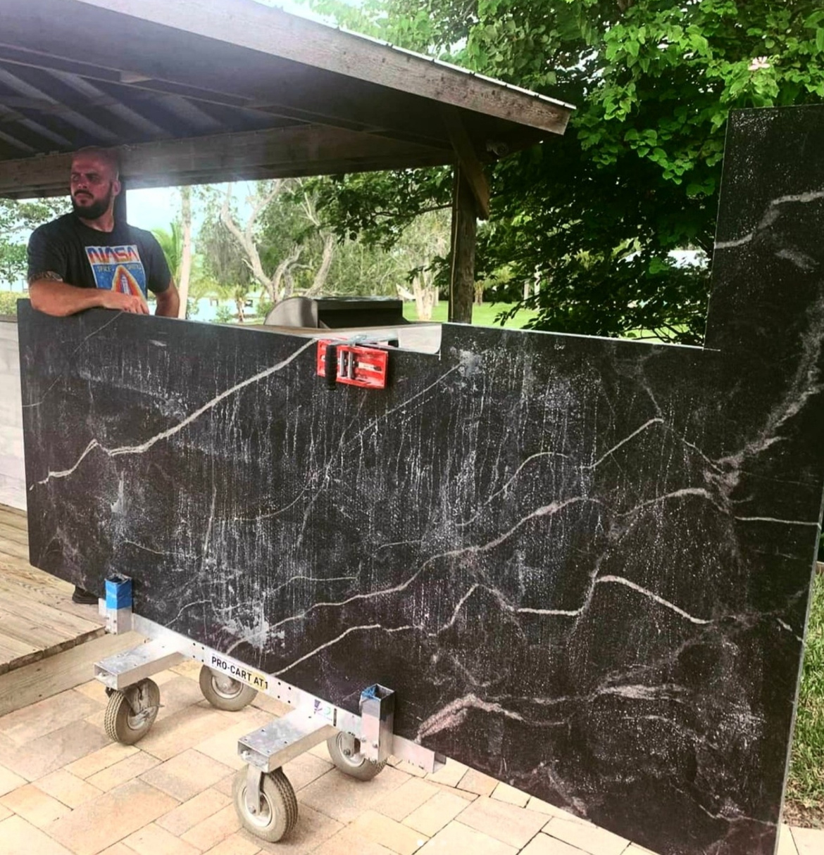 a person is standing in front of a large slab of black marble