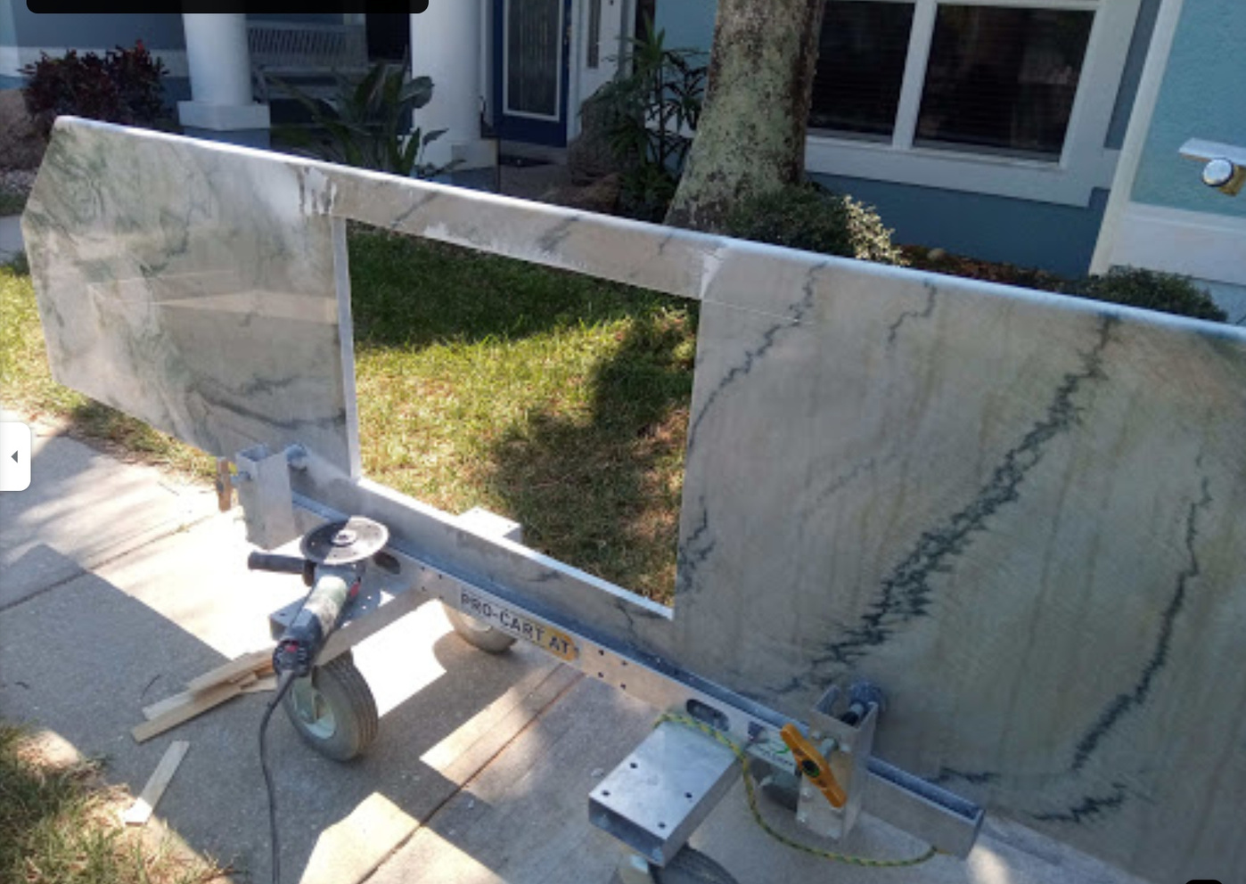 a person is working on a marble countertop in front of a house